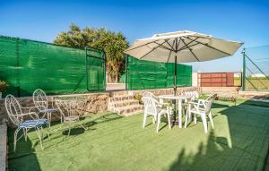 un patio con tavolo, sedie e ombrellone di Cozy Home In Puente Genil a Puente Genil Altre 17 foto