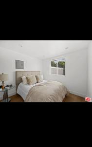 ein weißes Schlafzimmer mit einem Bett und einem Fenster in der Unterkunft Van Nuys Charming JDU! in Van Nuys Airport