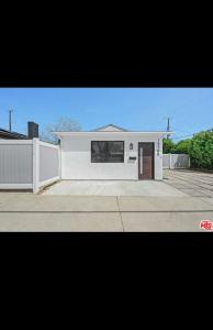 ein weißes Haus mit einem Zaun und einer Einfahrt in der Unterkunft Van Nuys Charming JDU! in Van Nuys Airport