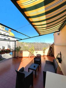 a patio with chairs and tables and awning at Terrazza Paradiso in Naples