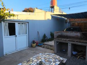 een achtertuin met een wit huis en een garage bij "La Violeta" casa con jardín y cochera, San Pedro in San Pedro