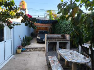 a patio with a bench and a car in a yard at "La Violeta" casa con jardín y cochera, San Pedro in San Pedro
