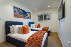 2 letti con cuscini arancioni in una camera di 3BR Aspen Townhouse - Walk everywhere ad Aspen