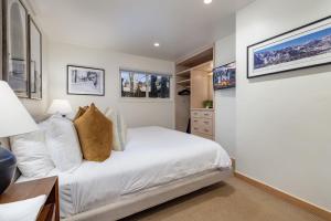una camera da letto con un letto con lenzuola e cuscini bianchi di 3BR Aspen Townhouse - Walk everywhere ad Aspen