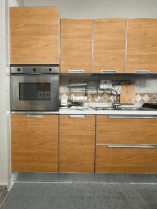 a kitchen with wooden cabinets and a microwave at Terrazza Paradiso in Naples
