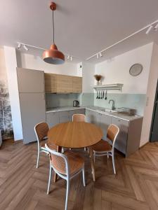 a kitchen with a wooden table and chairs in a kitchen at Apartament Forest Elegance in Charzykowy