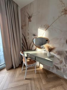 a desk with a mirror and a chair in a room at Apartament Forest Elegance in Charzykowy