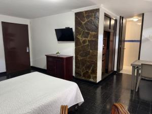um quarto de hotel com uma cama e uma parede de pedra em Vallclaire Suites em Barranquilla mais 37 fotografias