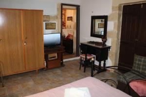 a bedroom with a bed and a desk with a television at TRADITIONAL HOUSE MARIA in Azoyirás