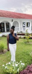 a woman standing in the grass in front of a house at Villa Eden in Pointe-Noire +43 photos