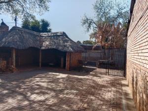 プレトリアにあるAmerican horsesの茅葺き屋根の建物への門