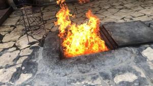 a fire is burning in a fire pit at مخيم الخال in Yarqā