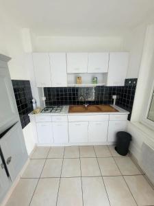 ChaulgnesにあるMaison cosy près du circuit Nevers Magny-Coursの白いキャビネットとシンクを備えた小さなキッチン +6枚の写真