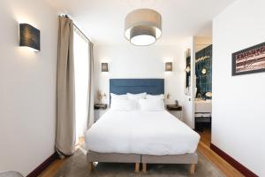 una camera da letto con un letto bianco e una grande finestra di Villa Lorenzo Chambres & Restaurant Barcelonnette Hotel a Barcelonnette