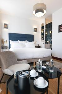 una camera d'albergo con un letto, un tavolo e delle sedie di Villa Lorenzo Chambres & Restaurant Barcelonnette Hotel a Barcelonnette