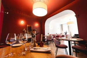 un ristorante con tavoli e sedie e una grande finestra di Villa Lorenzo Chambres & Restaurant Barcelonnette Hotel a Barcelonnette