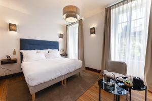 una camera da letto con un letto grande e una grande finestra di Villa Lorenzo Chambres & Restaurant Barcelonnette Hotel a Barcelonnette