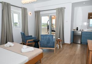 アダマスにあるAegean Blue - Volia Deluxe apartのベッドのある寝室とテーブルのあるキッチン