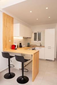 een keuken met een houten aanrecht en 2 krukken bij Modern 1 bedroom apartment in Athene