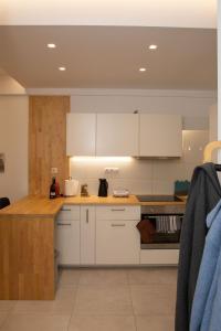 een keuken met witte kasten en een aanrechtblad bij Modern 1 bedroom apartment in Athene