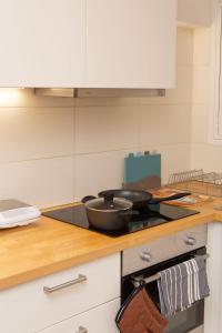 een keuken met een koekenpan op een fornuis bij Modern 1 bedroom apartment in Athene