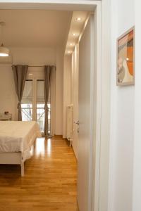 een witte slaapkamer met een bed en een hal bij Modern 1 bedroom apartment in Athene +7 foto's