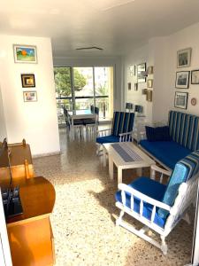 a living room with blue chairs and a table at EUROSOL Vacaciones PLAYA GANDIA in Playa de Gandia