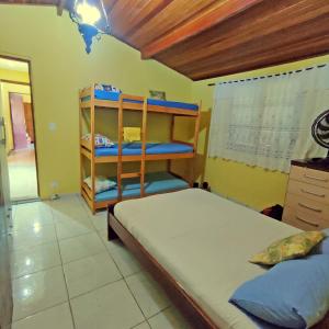 a bedroom with a bed and a wooden shelf at Sítio com piscina e lago in Salesópolis +43 photos