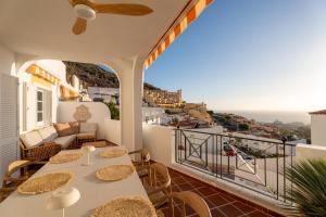 a balcony with tables and chairs and a view of the ocean at Mosaico Ocean View Boutique Apartment in Adeje