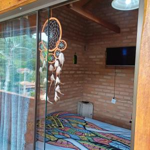a room with a bed and a glass window at Claudinha chalés in Conceição da Ibitipoca