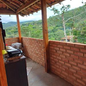 a patio with a brick wall with a view at Claudinha chalés in Conceição da Ibitipoca