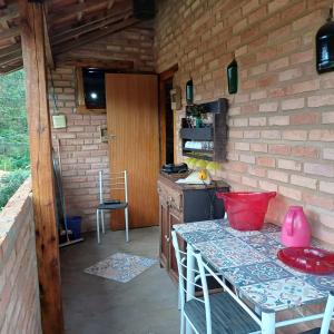 a kitchen with a counter and a table in a room at Claudinha chalés in Conceição da Ibitipoca