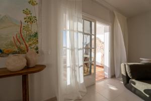 a living room with a sliding glass door to a patio at Mosaico Ocean View Boutique Apartment in Adeje