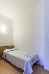 białe łóżko w pokoju z białą ścianą w obiekcie Hotel Franini w mieście Costa Volpino