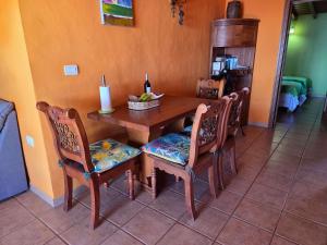 - une table à manger avec des chaises et une bouteille de vin dans l'établissement Casa Angel - Fuencaliente, à Fuencaliente de la Palma