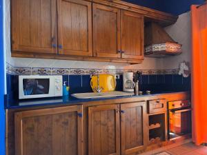 une cuisine avec des armoires en bois et un micro-ondes dans l'établissement Casa Angel - Fuencaliente, à Fuencaliente de la Palma 23 autres photos