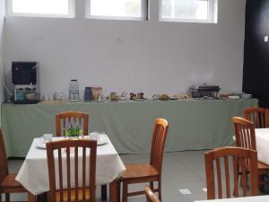 a dining room with a table and chairs and a counter at North Coast Camping in Biscoitos