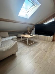 a living room with a couch and a table at Cozy apartment in Neuville-les-Dames