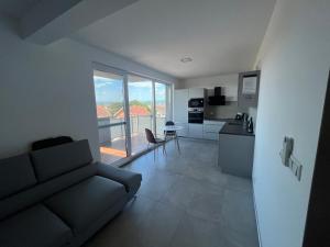 a living room with a couch and a kitchen at Apartment Sun Lakes pri Aquaparku in Senec