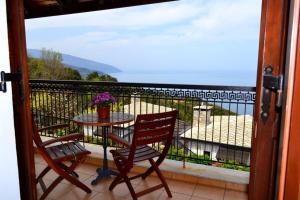 a balcony with two chairs and a table with a view at Hotel Aglaida Apartments in Tsagarada