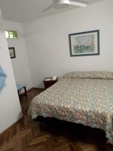 a bedroom with a bed and a picture on the wall at Casa María Josefina in Rosario