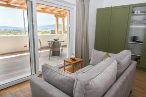 a living room with a couch and a table at Olive - Volia deluxe apartments in Adamas
