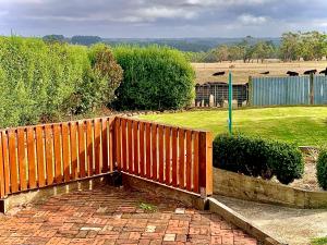 a wooden fence on top of a brick walkway at Rose Garden Retreat in Timboon