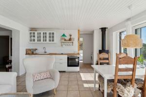 a kitchen and living room with a table and chairs at Lovely Beach House With Panoramic View in Martofte