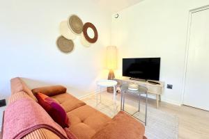 a living room with a couch and a flat screen tv at Charmant T2 - Plein coeur de Quimperlé in Quimperlé