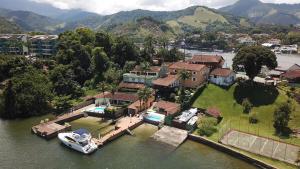 an aerial view of a house with a boat in the water at Vista dos sonhos na beira do mar de Angra com pier in Angra dos Reis