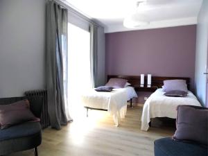 a bedroom with two beds and a window at L'Atelier S in Bagnols-les-Bains