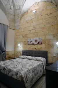 a bedroom with a bed and a brick wall at Casa vacanze da Pino A in Torchiarolo