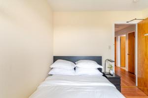 a bedroom with a bed with white sheets and pillows at Cozy and Secure 3-Bedroom, 2-Bath Unit with 6 Beds and Beautiful Bay View in Albany +18 photos