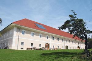 duży biały budynek z czerwonym dachem w obiekcie Waldbothgut w Linzu